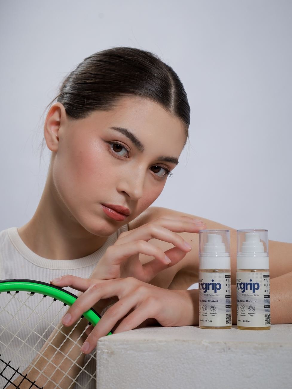Player leaning on a racket beside two bottles