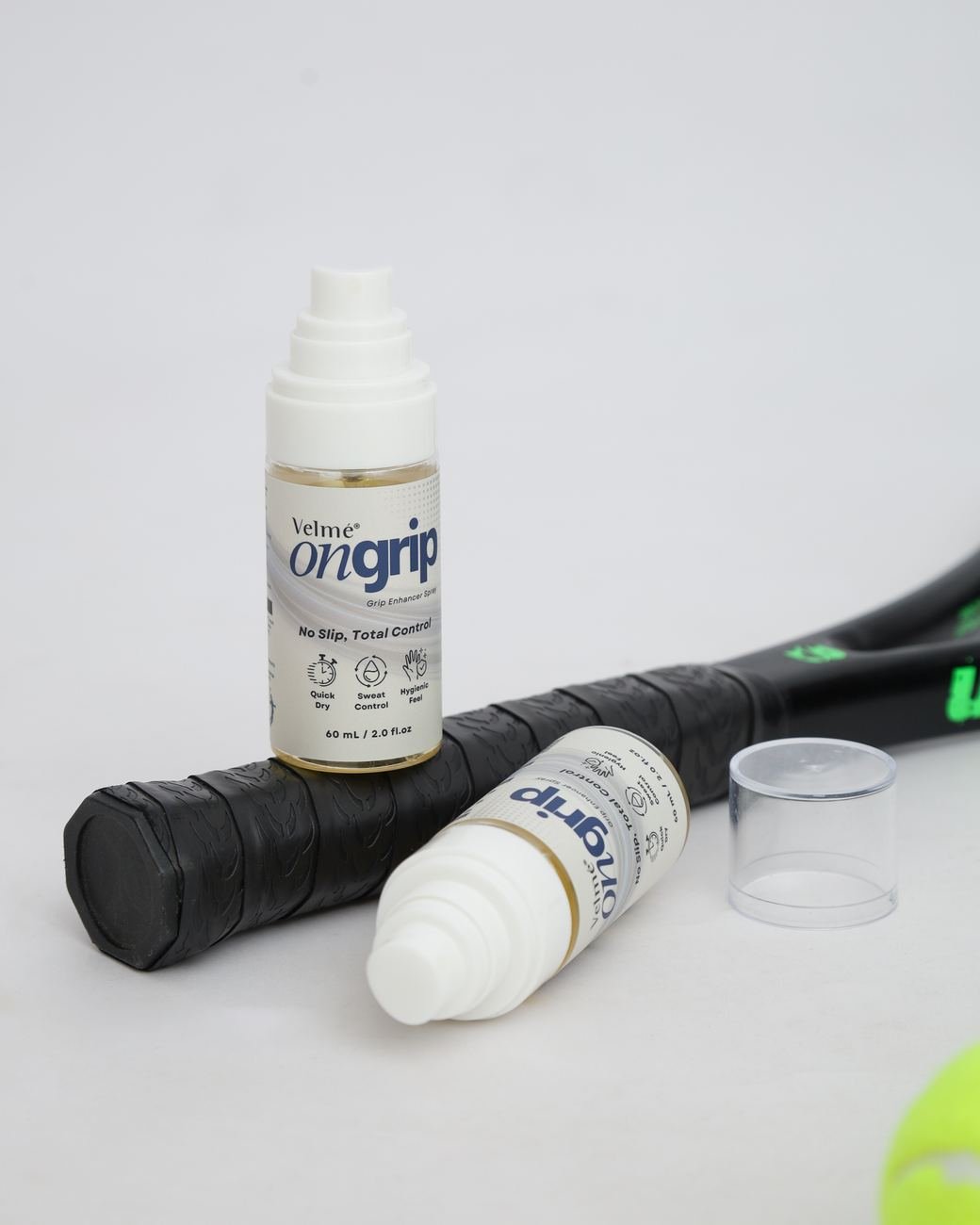 ONGrip bottles resting on a racket handle